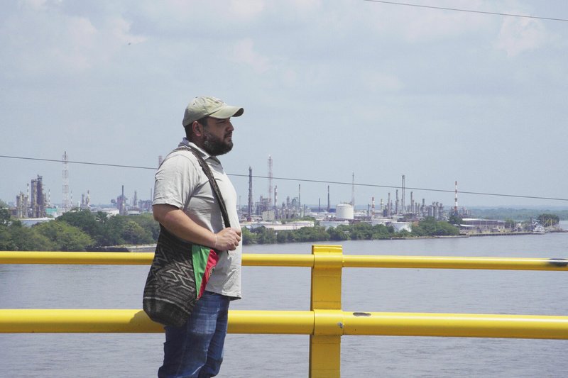 Óscar Sampayo, Environmental Defender, stands on a bridge at the San Silvestre wetlands, near Barrancabermeja, Colombia. Óscar had to leave Barrancabermeja after facing threats when he spoke out against pollution from big industry.